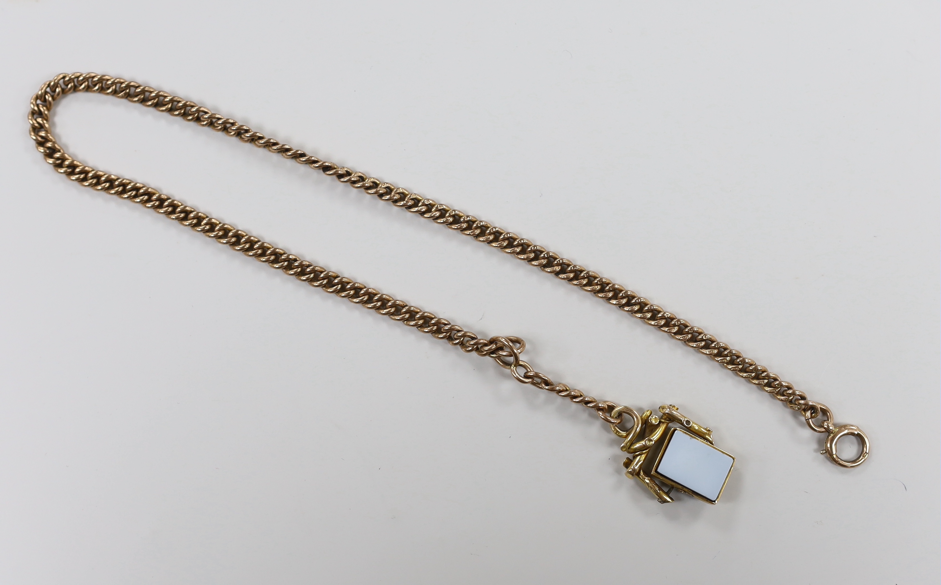 An early 20th century 9ct gold curb link chain, 39cm, hung with an Austro Hungarian yellow metal and chalcedony set spinning fob, gross weight 47.1 grams.